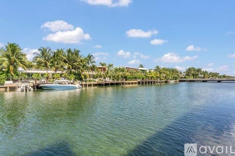 A boat is docked at a pier with palm trees in the background.