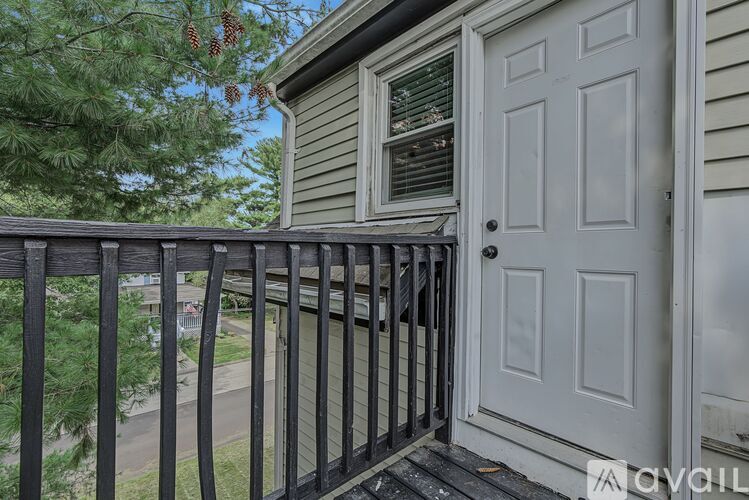 A balcony with a white door and a black railing.