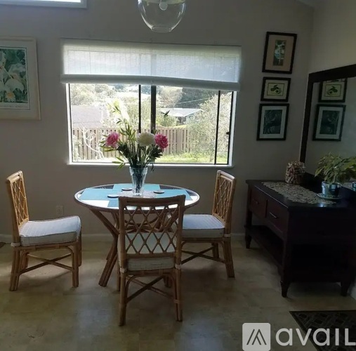 A dining room with a table and chairs.