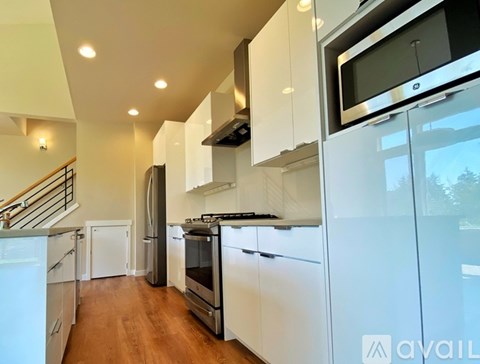 A modern kitchen with white cabinets and stainless steel appliances.