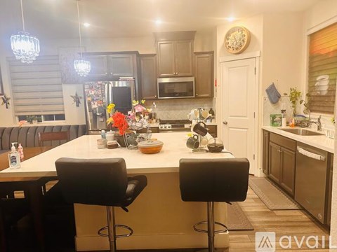 A kitchen with a bar stool and a counter with a clock on it.