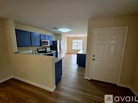 A kitchen with dark blue cabinets and a white counter.
