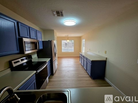 A kitchen with dark blue cabinets and a stainless steel sink.
