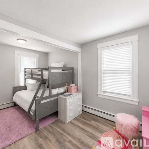 A bedroom with a bunk bed and a pink rug.