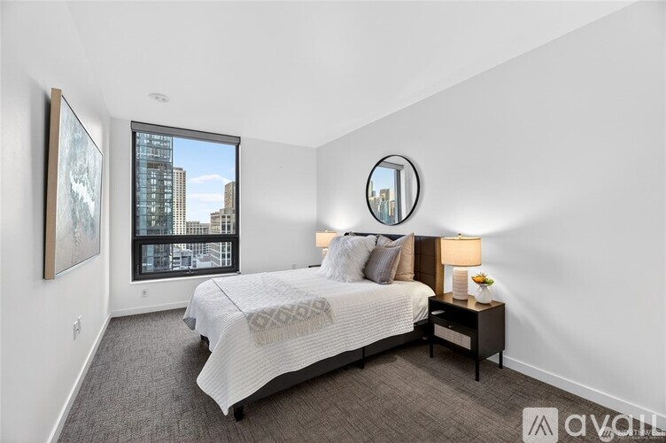 A bedroom with a large bed and a round mirror on the wall.