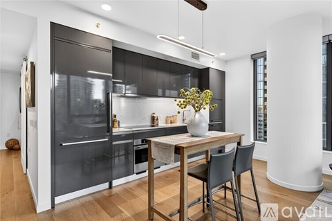 A modern kitchen with a wooden table and chairs.