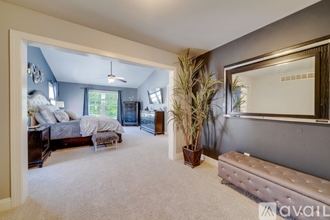 A bedroom with a large bed and a mirror on the wall.