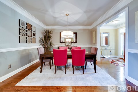 A dining room with a table and chairs.