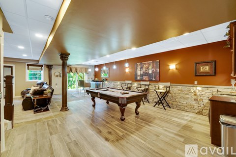 A room with a pool table and a bar.