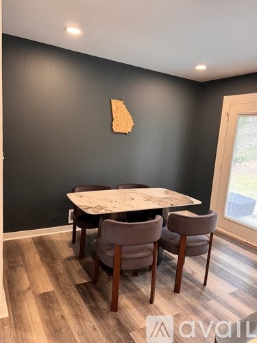 A dining room with a table and chairs.
