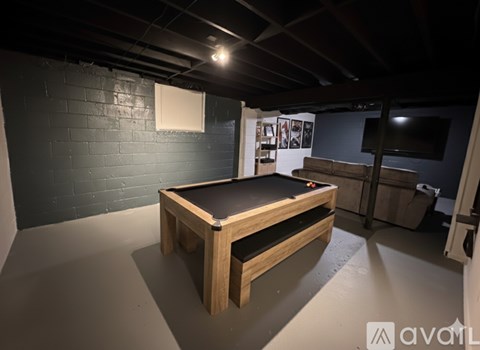 A pool table in a room with a brick wall.