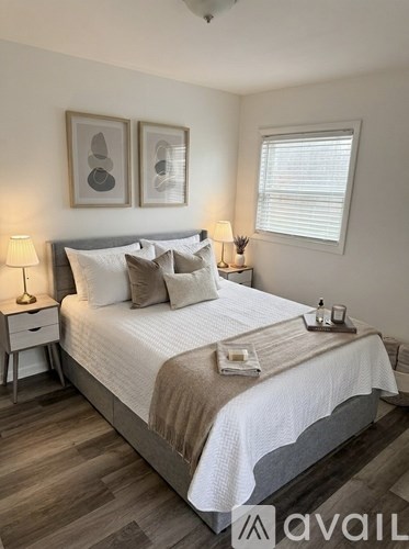 A bedroom with a large bed and two lamps.