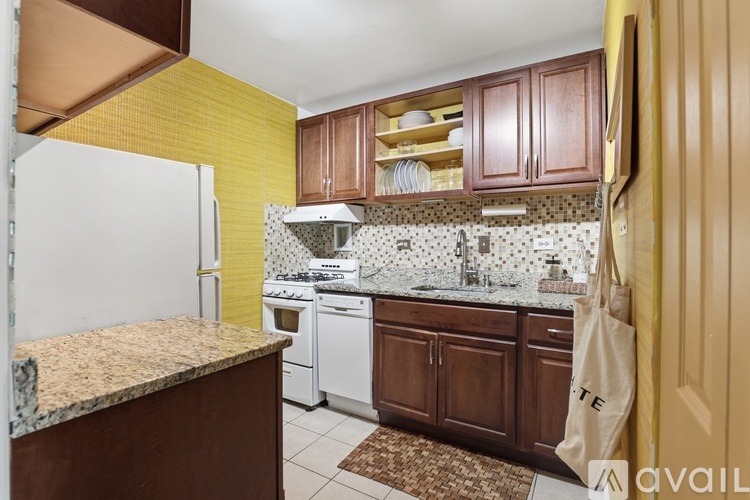 A kitchen with brown cabinets and a white refrigerator.