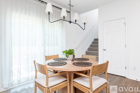 A dining room with a wooden table and chairs.