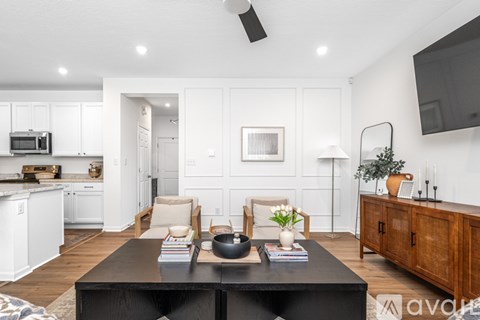 A modern living room with a black coffee table and white walls.