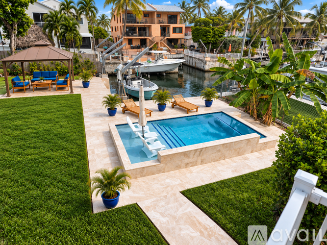 A small pool with a waterfall in the middle of a backyard.