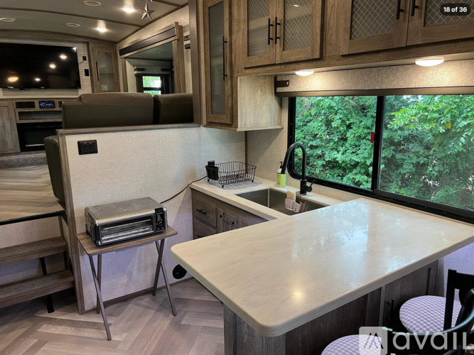 A kitchen area with a table and chairs, a microwave, and a sink.