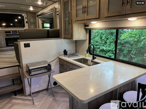 A kitchen area with a table and chairs, a microwave, and a sink.
