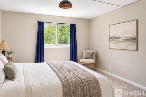 A bedroom with a large bed and a painting on the wall.