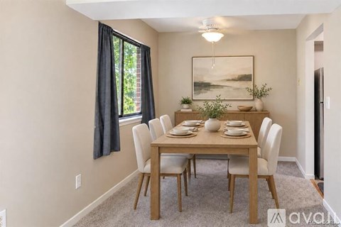 A dining room with a wooden table and chairs.