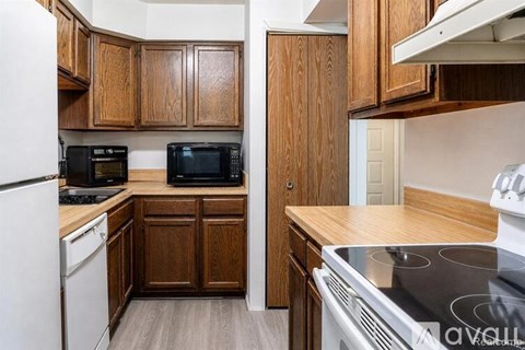 A kitchen with wooden cabinets and a white stove.