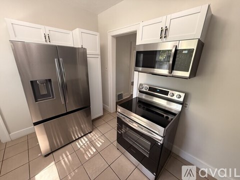 A kitchen with a stainless steel refrigerator, microwave, oven, and cabinets.