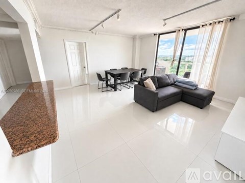 A spacious living room with a dining table and chairs.