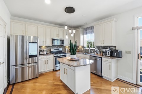 A kitchen with white cabinets and a central island.