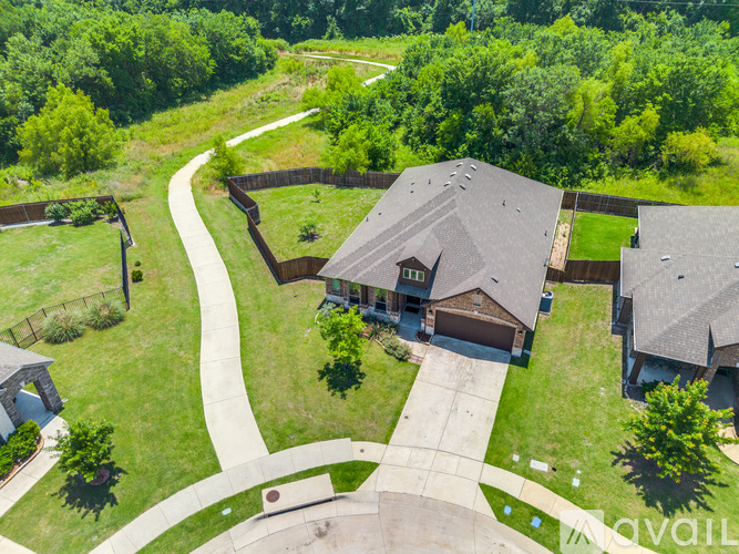 A house with a driveway and a fence in front of it.
