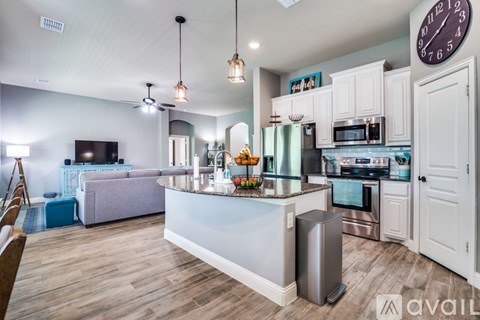 A kitchen with a white counter and a clock on the wall.