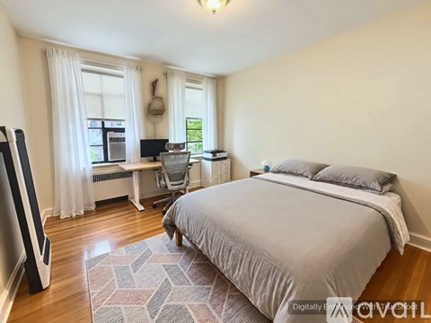 A bedroom with a bed, chair, and window.