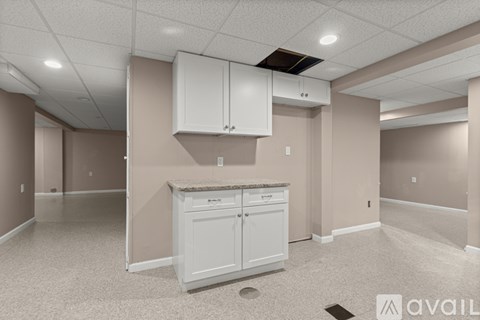 A kitchen area with a white cabinet and a countertop.