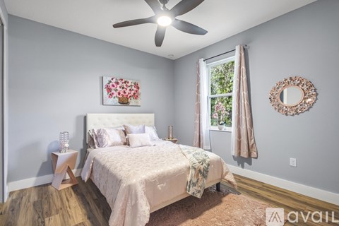 A bedroom with a large bed and a window with curtains.