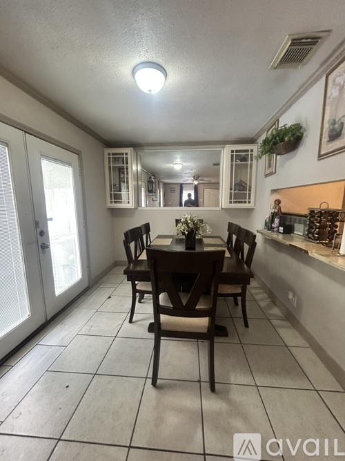 A dining room with a table and chairs.