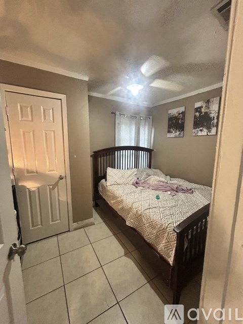 A bedroom with a bed, a door, and pictures on the wall.