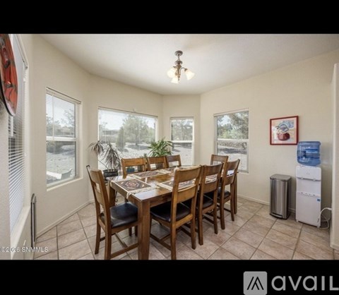 A dining room with a table and chairs.