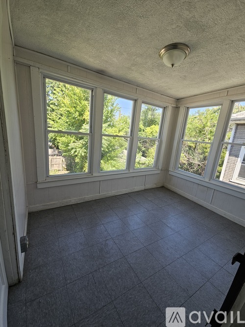 A sunny room with large windows and a tiled floor.