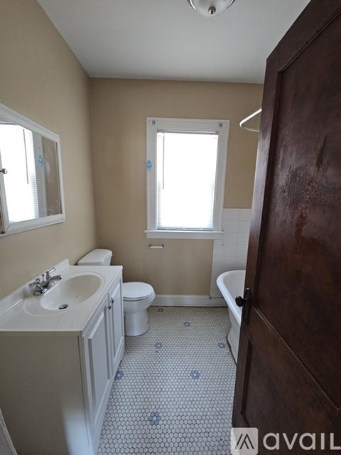 A bathroom with a toilet, sink, and tub.