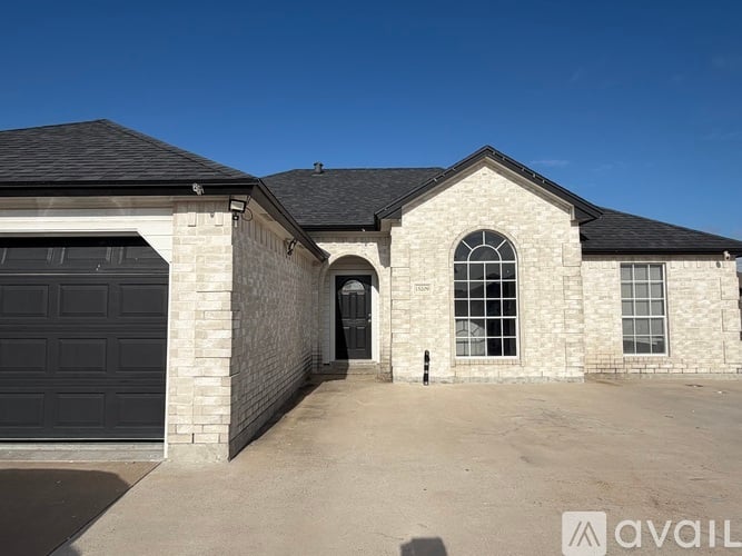 A house with a black garage door and a stone wall.
