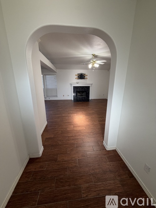 A hallway with a fan and a fireplace.