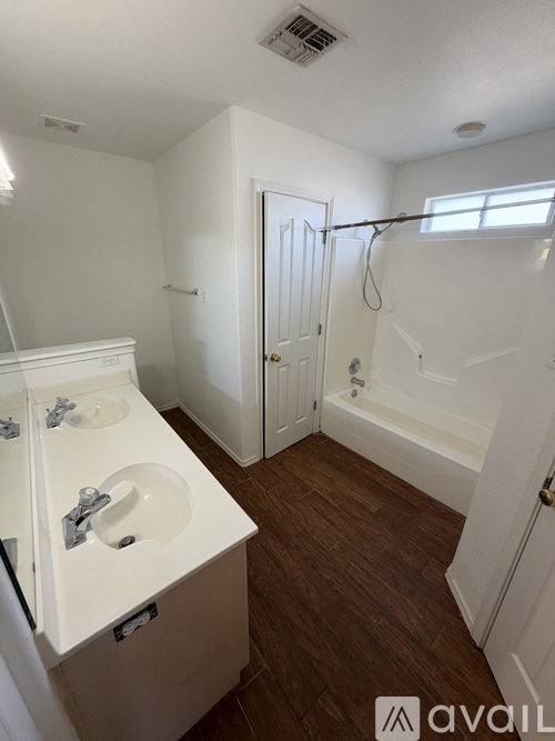 A small bathroom with a sink, mirror, and bathtub.