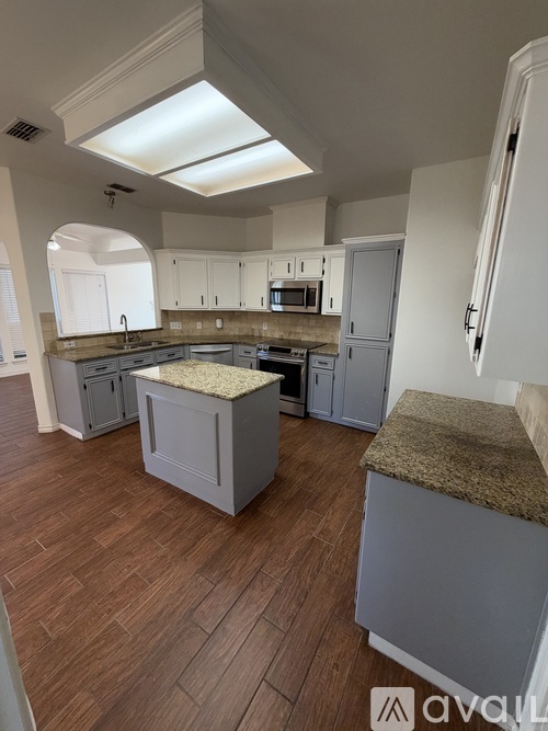 A kitchen with a skylight above the island.