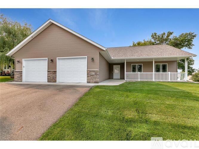 A house with a brown roof and white garage doors.