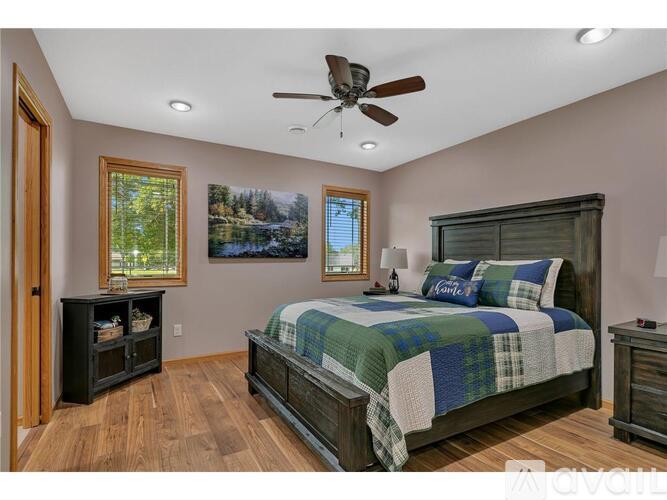 A bedroom with a bed, dresser, and a ceiling fan.