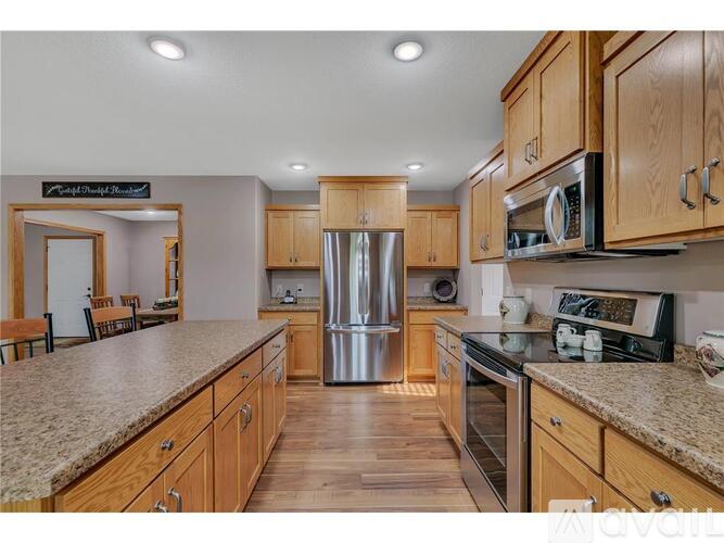 A kitchen with wooden cabinets and a granite countertop.