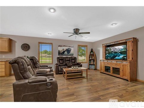 A living room with a row of recliner chairs and a television.