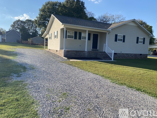 A house with a gravel driveway in front.