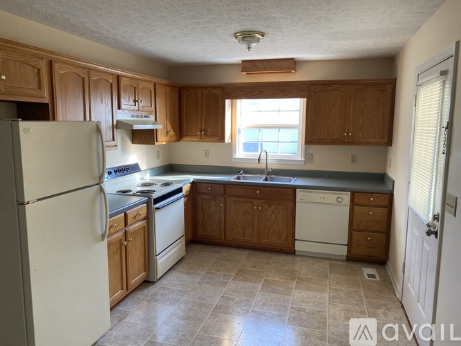 A kitchen with wooden cabinets and a white refrigerator.