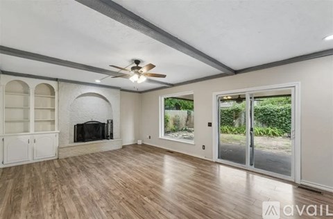 A living room with a fireplace and a ceiling fan.
