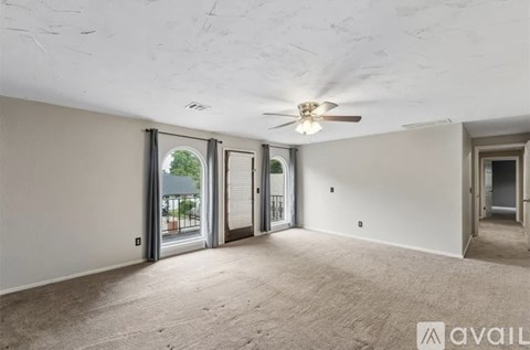 A spacious room with a ceiling fan and sliding glass doors.